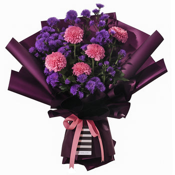 A striking gallery-art featuring full pink chrysanthemums and delicate purple asters. It is elegantly wrapped in deep purple paper with a modern black and white striped accent at the base. The arrangement is tied with a pink ribbon bow, creating a full, rounded shape. This sophisticated gallery-art is perfect for birthdays, anniversaries, or as a thoughtful thank-you gesture.